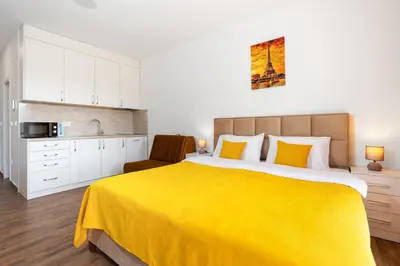 a bedroom with a large bed with a yellow blanket at Apartment San Riviera in Bar