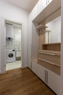 a kitchen with white cabinets and a washer and dryer at Sea Breeze apartment in Bar