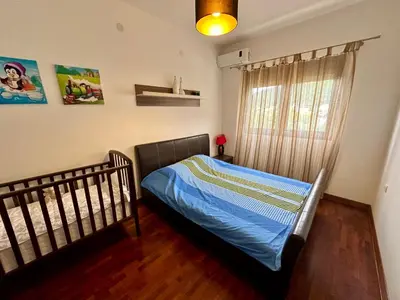a bed in a bedroom with a crib and a window at Velvet apartment Petrovac in Petrovac na Moru