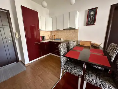 a kitchen with a table and chairs in a room at Velvet apartment Petrovac in Petrovac na Moru