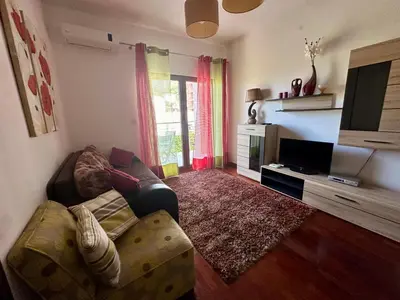 a living room with a couch and a television at Velvet apartment Petrovac in Petrovac na Moru