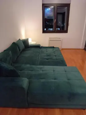 a green bed in a room with a green couch at 2 bedroom apartment blok 9 in Podgorica
