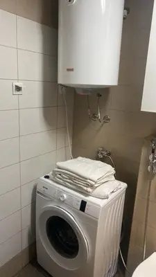 a washing machine with towels on top of it at 2 bedroom apartment blok 9 in Podgorica