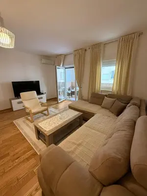 a living room with a large couch and a table at Stan 60m2 in Bar