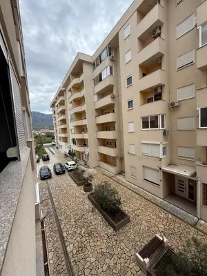 an apartment building with cars parked in a courtyard at Stan 60m2 in Bar