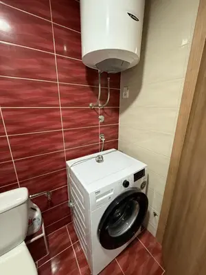 a bathroom with a washing machine and a toilet at Stan 60m2 in Bar
