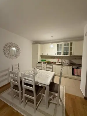 a kitchen with a white table and chairs in it at Stan 60m2 in Bar