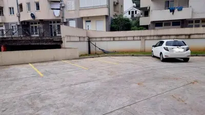 a white car parked in a parking lot at Tehnoplus apartment in Budva