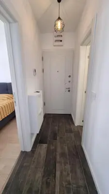 a hallway with a bed and a white door at Tehnoplus apartment in Budva