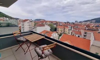 a balcony with two chairs and a table on a roof at Tehnoplus apartment in Budva