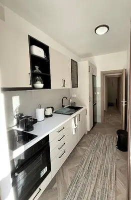 a kitchen with white cabinets and a stove top oven at Apartment Studio Z&M in Kotor