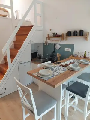 a kitchen with a table and chairs and a staircase at Bonaca Home Kotor in Kotor