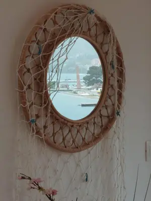 a round mirror hanging on a wall with a window at Bonaca Home Kotor in Kotor