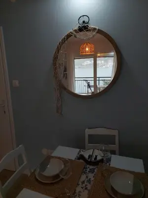 a dining room with a mirror and a table at Bonaca Home Kotor in Kotor