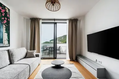 a living room with a couch and a flat screen tv at Vuelo Sobre by In Property in Becici