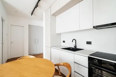a kitchen with white cabinets and a wooden table at Vuelo Sobre by In Property in Becici