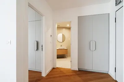 a hallway with white cabinets and a bathroom with a sink at Vuelo Sobre by In Property in Becici