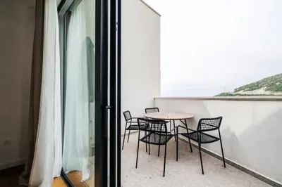 a table and chairs on a balcony with a window at Vuelo Sobre by In Property in Becici