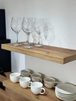 a wooden shelf with wine glasses and cups on it at Olive Branch Studio Apartment Dobra Voda in Bar