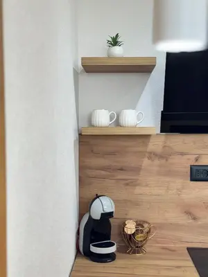 a kitchen with a coffee maker on a wooden floor at Olive Branch Studio Apartment Dobra Voda in Bar