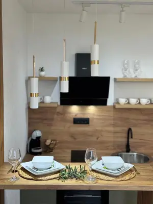 a table with two plates and glasses on it at Olive Branch Studio Apartment Dobra Voda in Bar