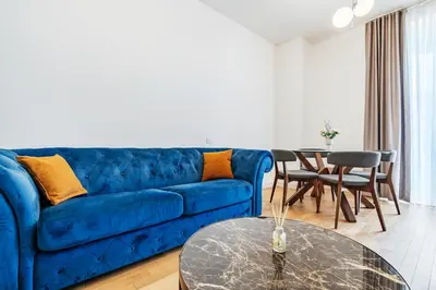 a living room with a blue couch and a table at Luna skyline sea view apt in Budva