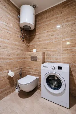 a bathroom with a washing machine and a toilet at Luna skyline sea view apt in Budva