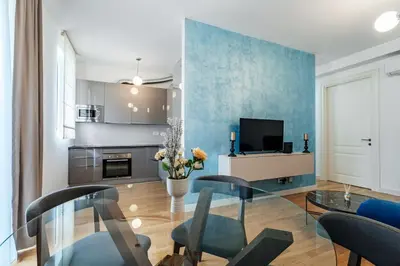a living room with a glass table and a tv at Luna skyline sea view apt in Budva