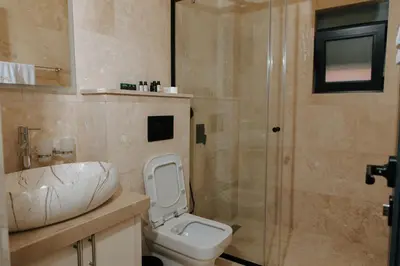 a bathroom with a toilet and a sink and a shower at Hermosa Hotel in Donji Štoj