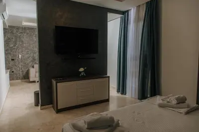 a bedroom with two beds and a flat screen tv at Hermosa Hotel in Donji Štoj