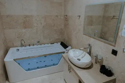 a bathroom with a tub and a sink and a mirror at Hermosa Hotel in Donji Štoj