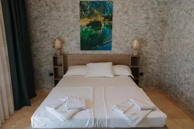 a bedroom with a bed with two towels on it at Hermosa Hotel in Donji Štoj