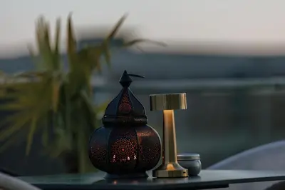 a table topped with a lamp and a candle at Hermosa Hotel in Donji Štoj