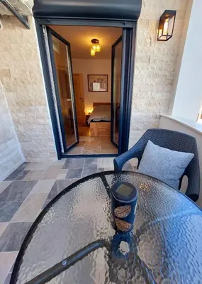 a glass table in the middle of a patio at Green Castle in Kunje
