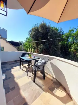 a patio with a table and chairs and an umbrella at Green Castle in Kunje