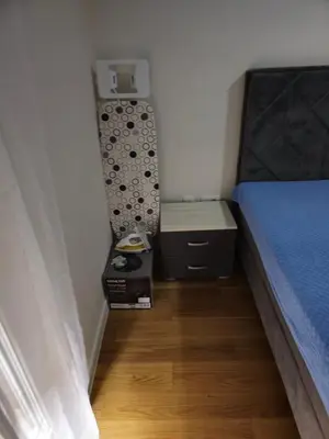 a small bedroom with a bed and a night stand at Central Point apartment in Podgorica