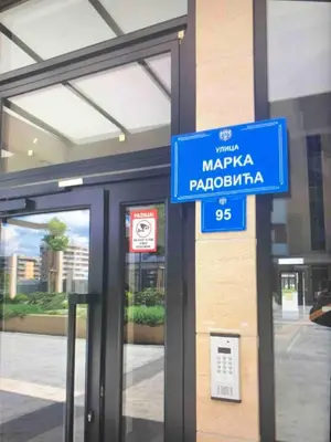a blue sign in front of a building at Central Point apartment in Podgorica