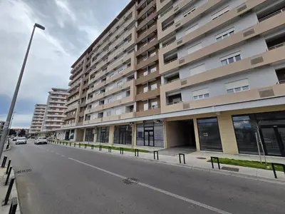 an empty street in front of a large building at Central Point apartment in Podgorica
