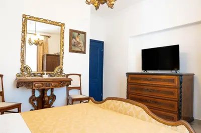 a bedroom with a bed and a mirror and a tv at Glanz Antique Paradise near the Sea in Kotor