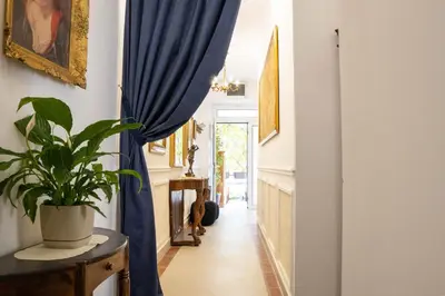 a hallway with blue curtains and a potted plant at Glanz Antique Paradise near the Sea in Kotor