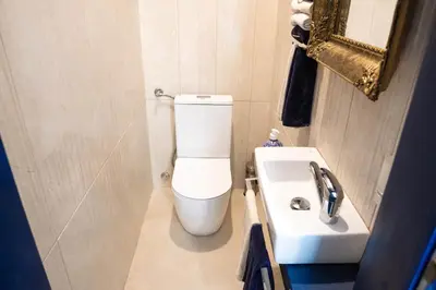 a bathroom with a white toilet and a sink at Glanz Antique Paradise near the Sea in Kotor