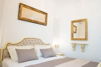 a bedroom with a bed and a mirror on the wall at Glanz Antique Paradise near the Sea in Kotor