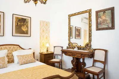 a bedroom with a bed and a mirror and a table at Glanz Antique Paradise near the Sea in Kotor