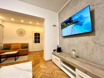a living room with a flat screen tv on a wall at Three bedroom apartment Budva in Budva
