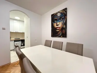 a white table with chairs and a painting on the wall at Three bedroom apartment Budva in Budva