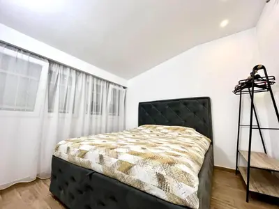 a bedroom with a black bed and a window at Three bedroom apartment Budva in Budva