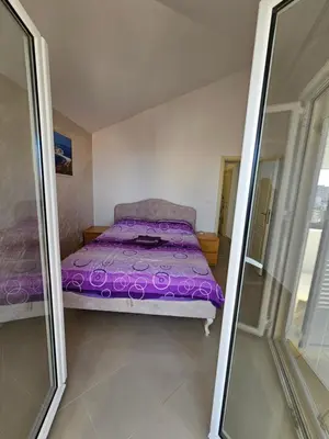 a bedroom with a purple bed and a mirror at Tirke Apartment in Becici