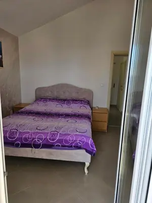 a bed with a purple comforter in a bedroom at Tirke Apartment in Becici