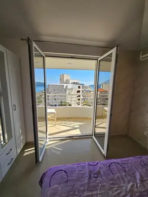 a bedroom with a bed and a view of a city at Tirke Apartment in Becici