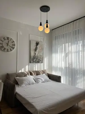 a bedroom with a large bed with a clock on the wall at Orzeja apartments in Ulcinj